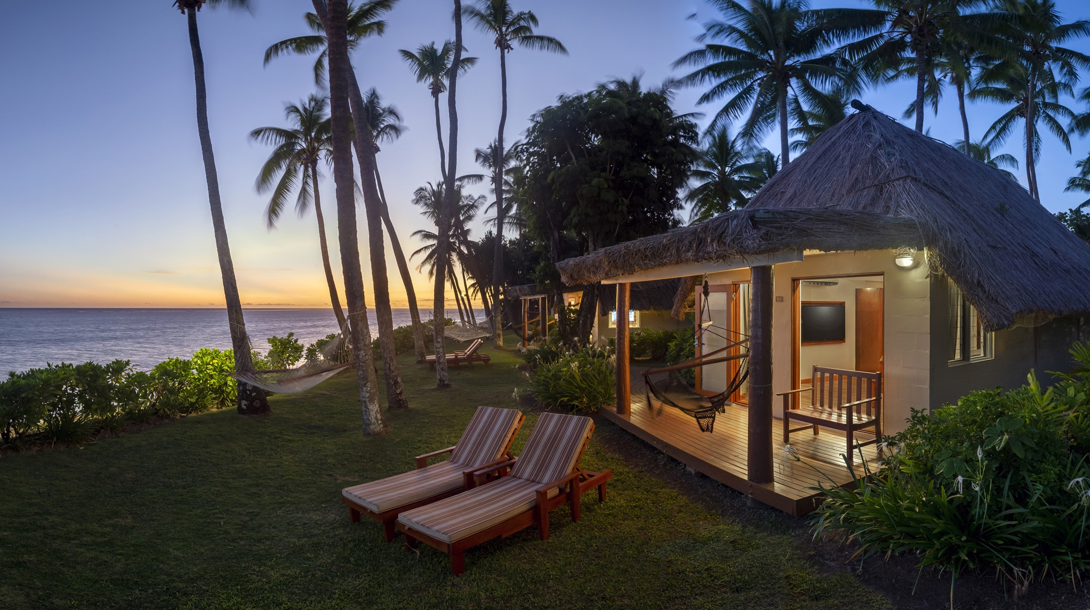 The Beachfront Bures at Outrigger Fiji Beach Resort are nestled amid palm trees, directly on the sandy shore— Photo by S Hotels & Resorts