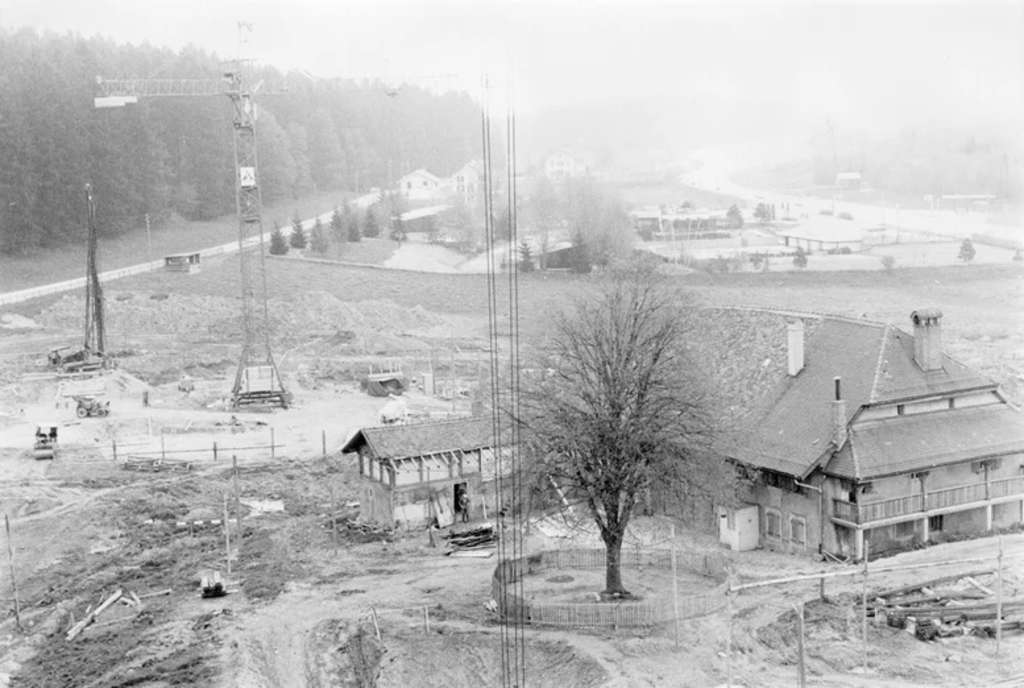 Figure 5: Construction of the Nouvelle École: the farm amid tower cranes, 1974. [EHL Archives, Audiovisual, CH-000963-7 AV-PH-BH-1974-3-1-2, 1974.]— Source: EHL